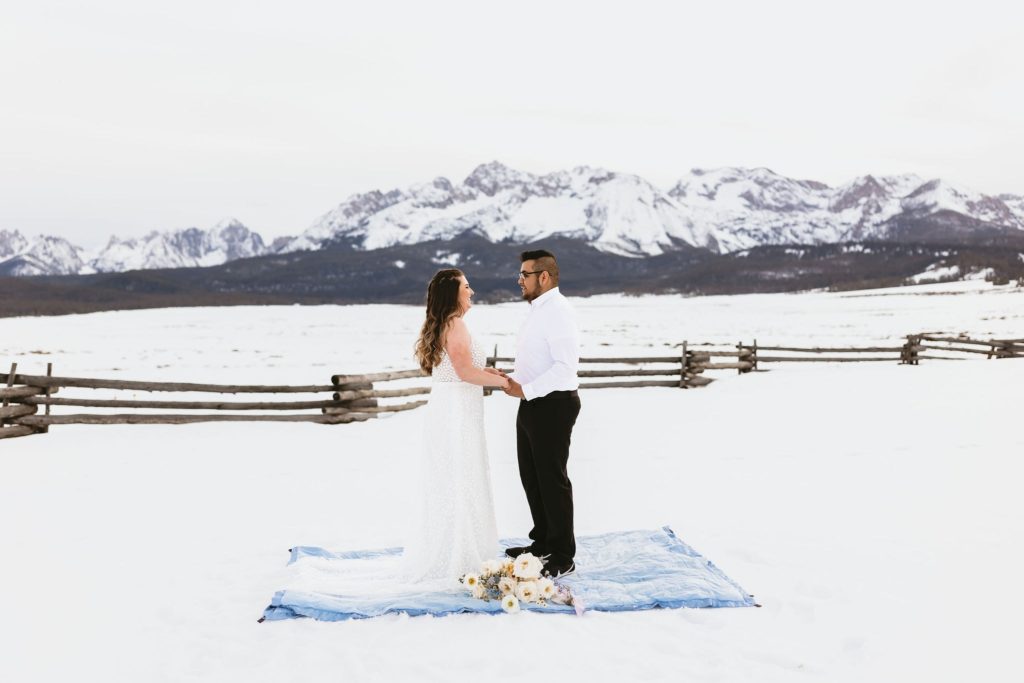 a couple who is saying their vows to each other in stanley, idaho in front of the mountains