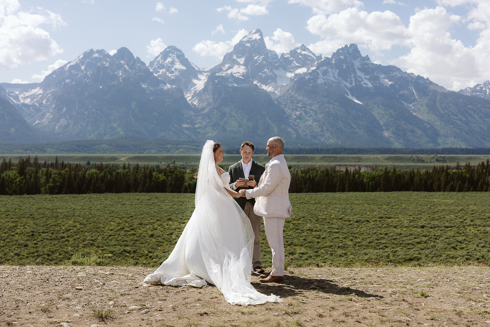 A couple during their elopement ceremony at Glacier View Turnout in Grand Teton National Park
