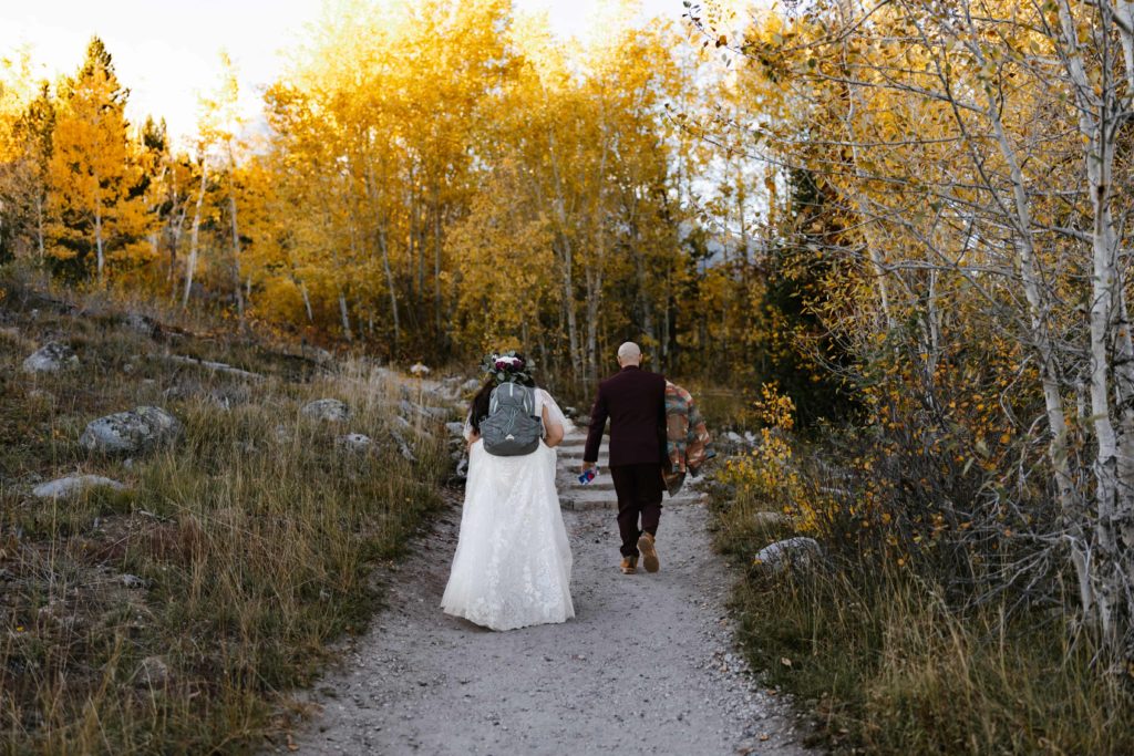 A bride and groom hiking up to Taggart Lake on their elopement day in Grand Teton National Park
