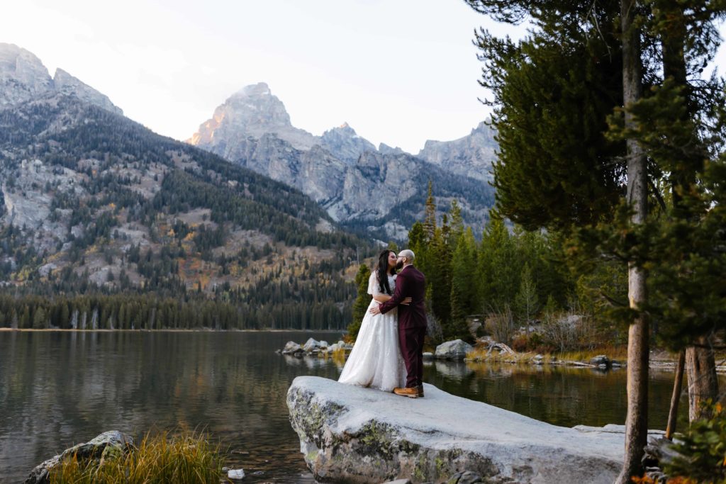 A couple standing on the shore of Taggart Lake during their Grand Teton National Park elopement in Wyoming