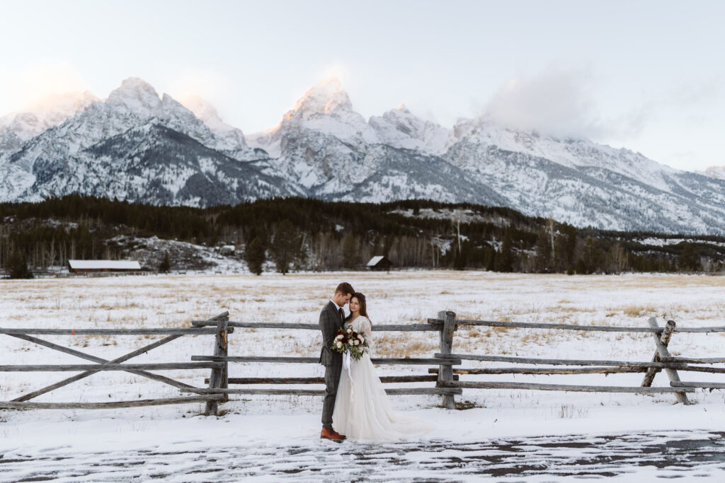 a newly married couple snuggling in front of the grand teton after their wedding day, which is a top venue in Jackson Hole, Wyoming