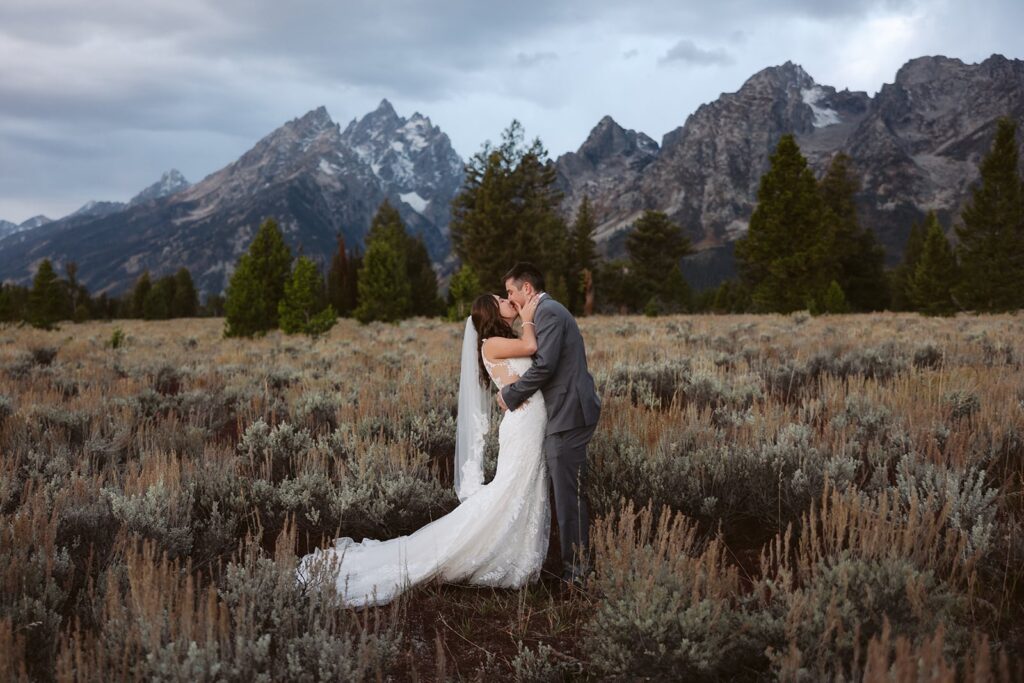 couples kissing after getting married at mountain view turnout ceremony location in grand teton national park