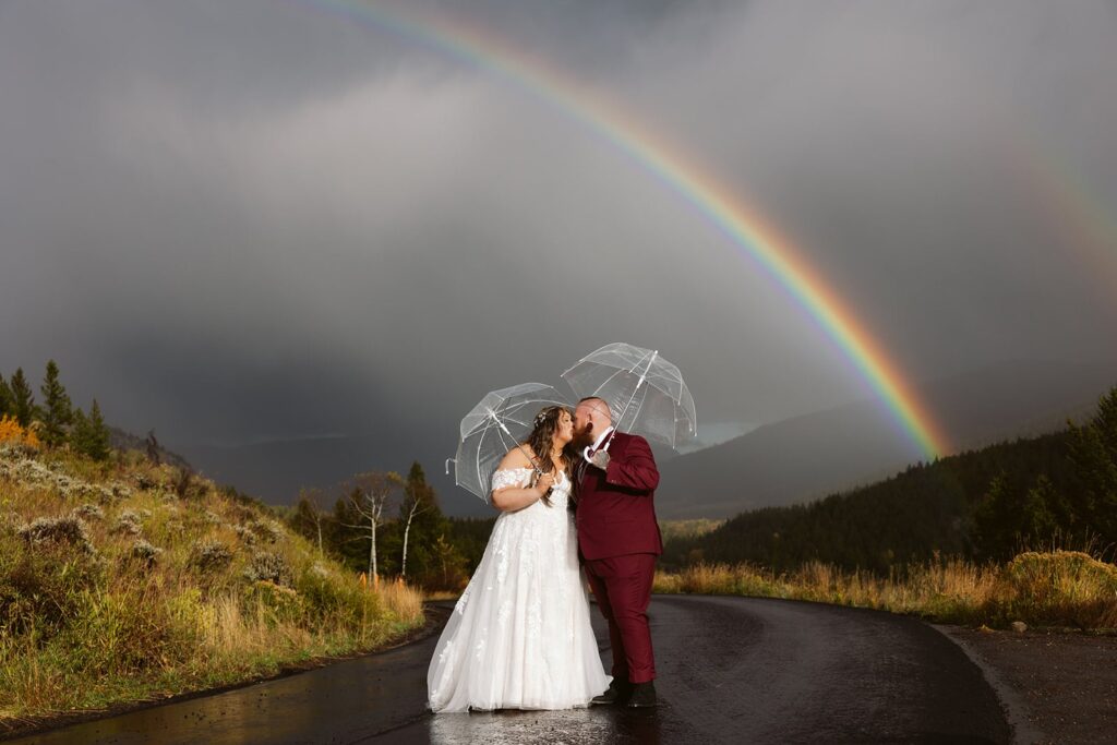 couple kissing under a double rainbow in jackson wyoming