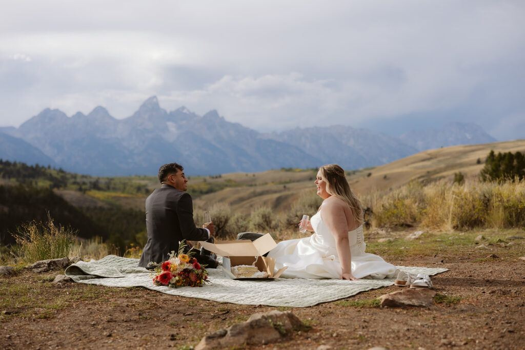 A couple having a picnic at the wedding tree in wyoming after their wedding ceremony